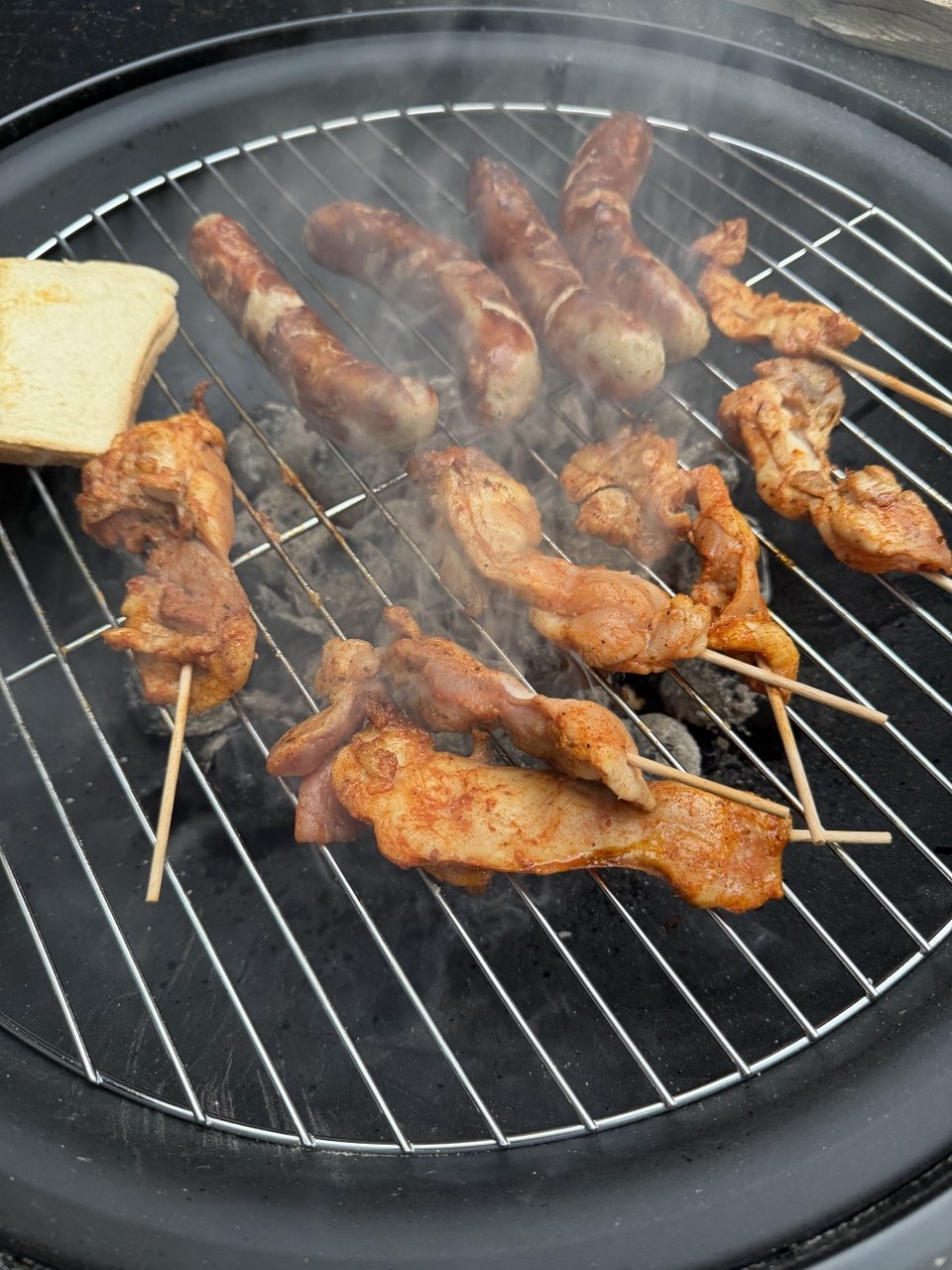 Schaschlik-Spieße und Würstchen auf dem Kugelgrill – selbst gegrillt