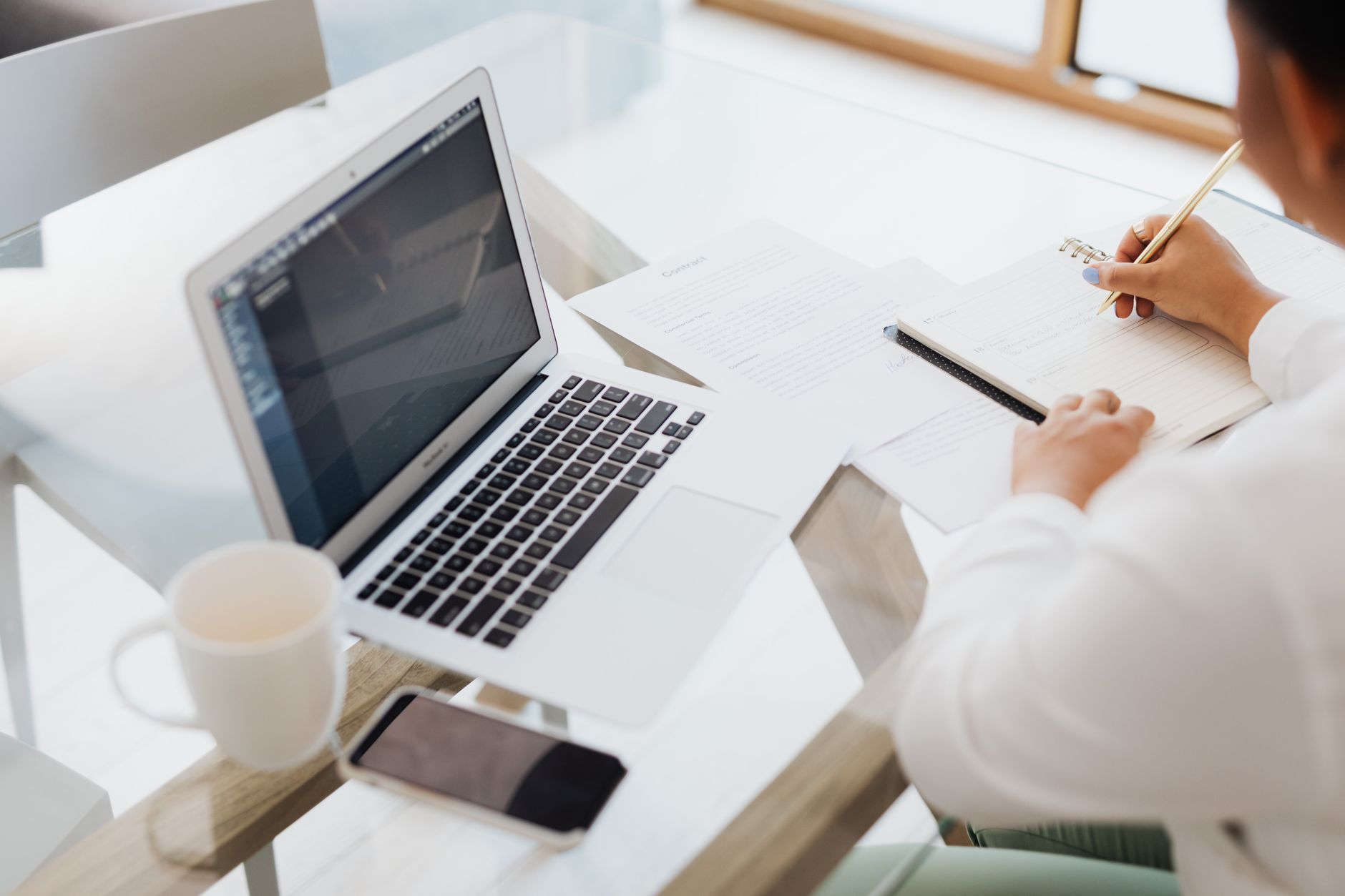 Person schreibt Businessplan am Schreibtisch