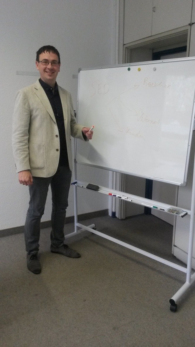 Dmytro Nechepurenko im Anzug vor dem Whiteboard mit SEO-Strategie 2014