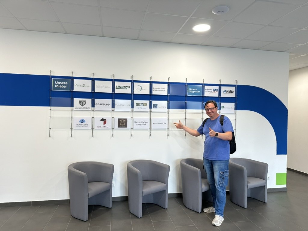 Dmytro Nechepurenko im Business-Inkubator WiReGo – zeigt auf Unternehmenslogos