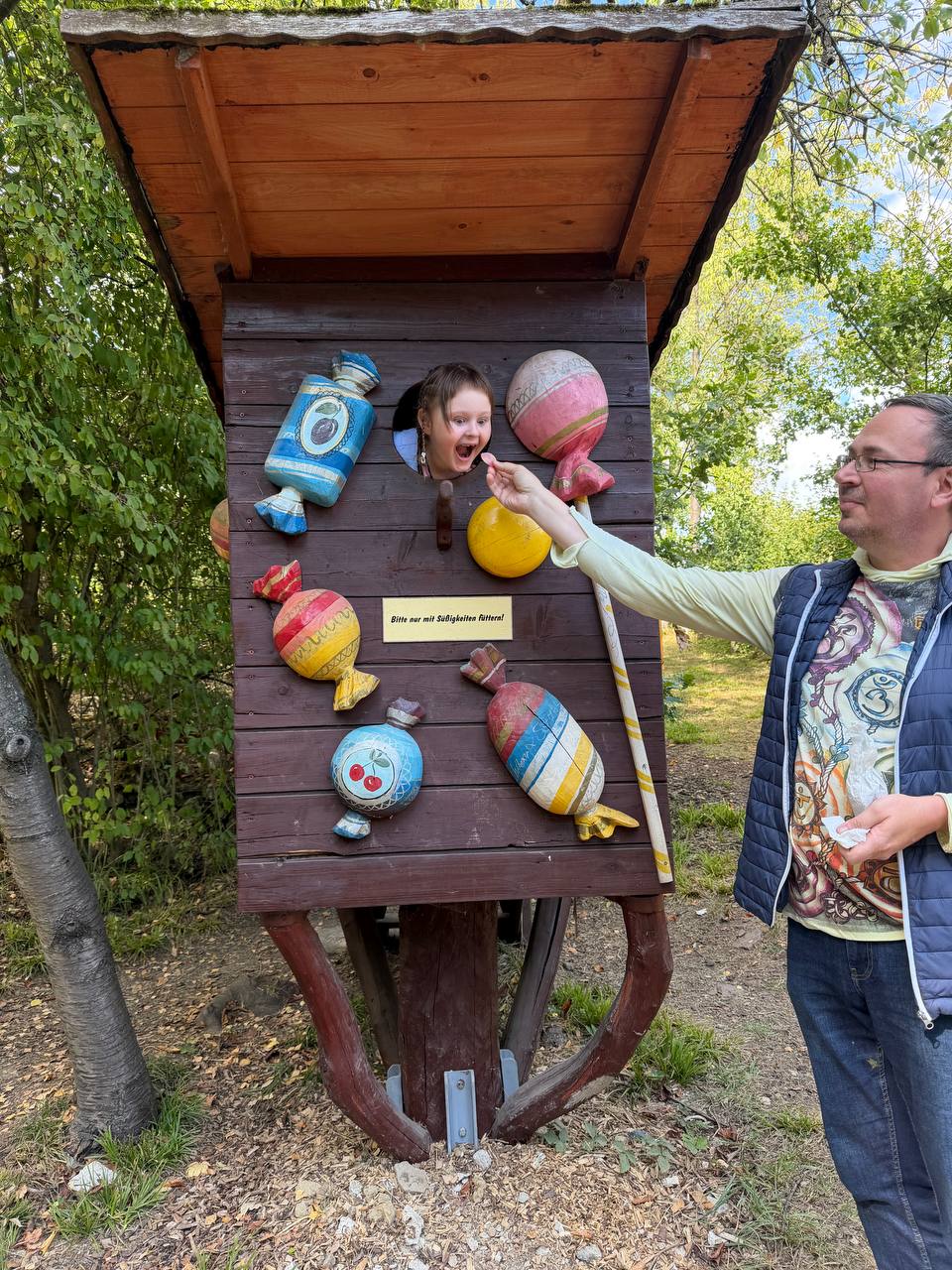 Vater füttert Tochter durch eine Spielinstallation im Park – Ikigai Moment
